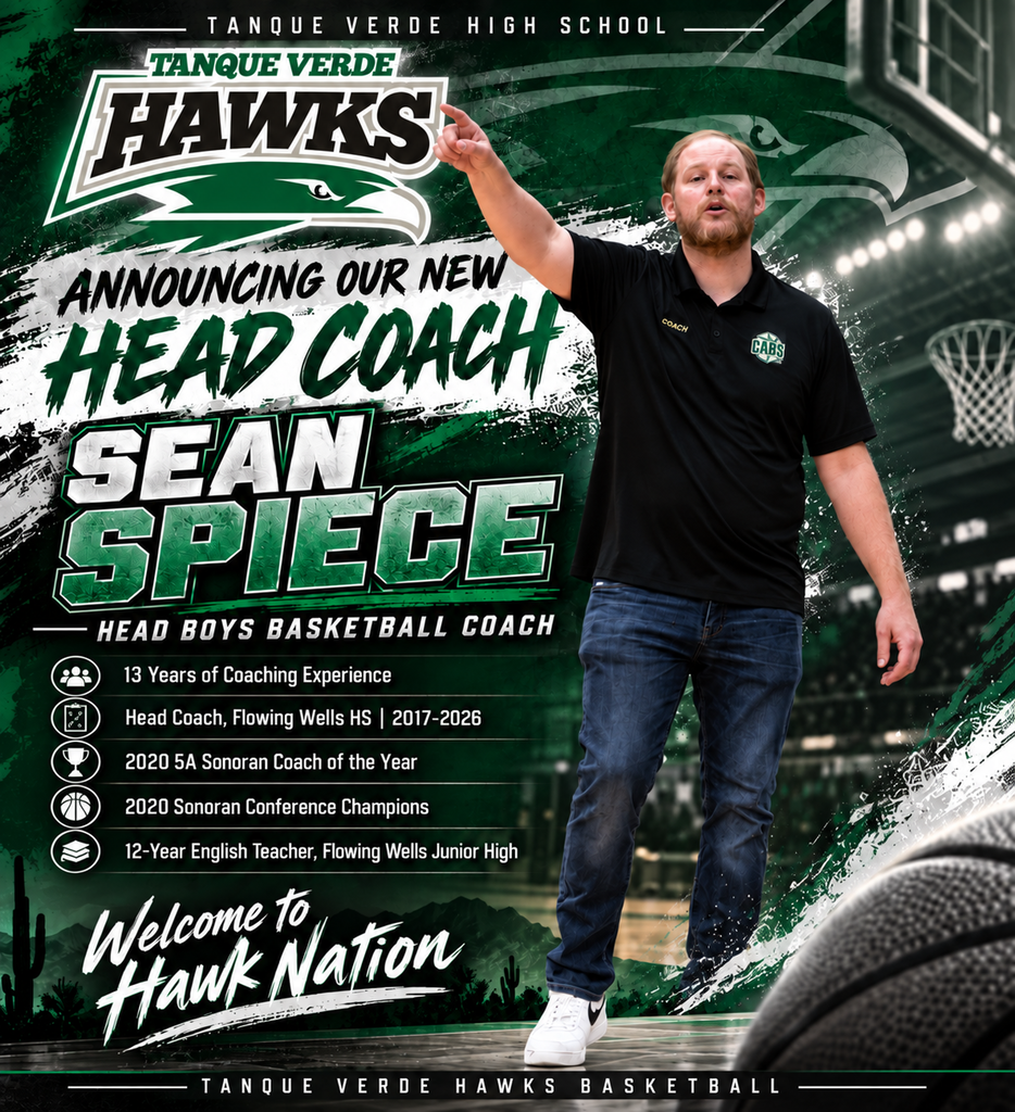 A man in a black shirt and jeans points at a basketball hoop. He is the new head coach.