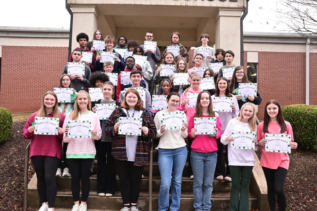 Picture of the students of the quarter standing on the steps with their certificates. 