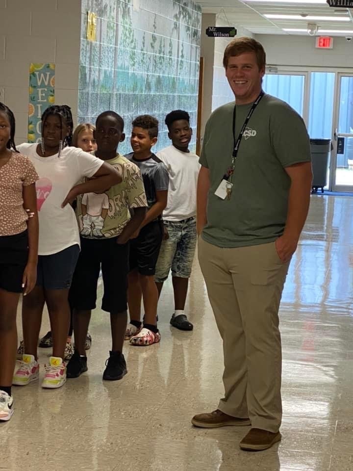 students standing in hallway with teacher