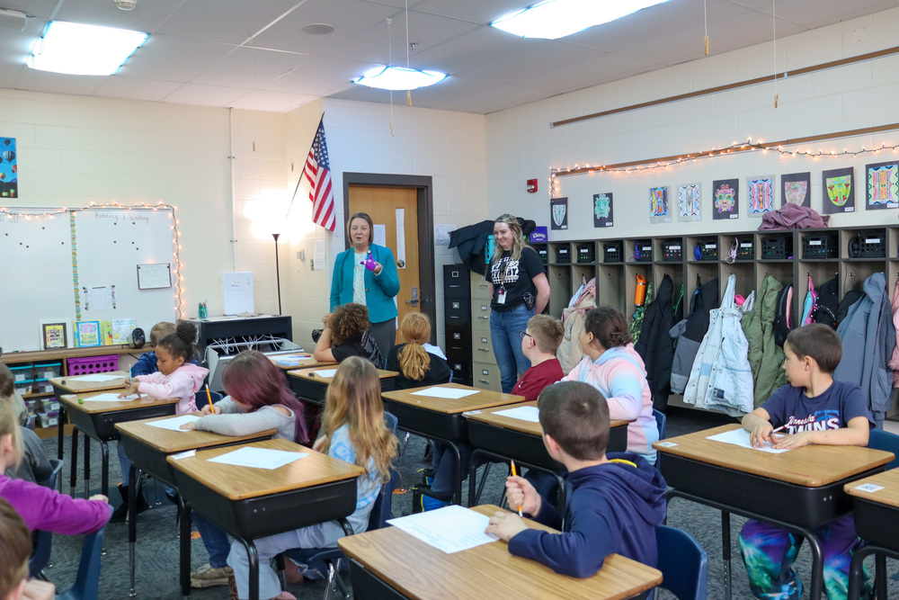 Dr. Guffin delivering a fish award to Ms. Bierne