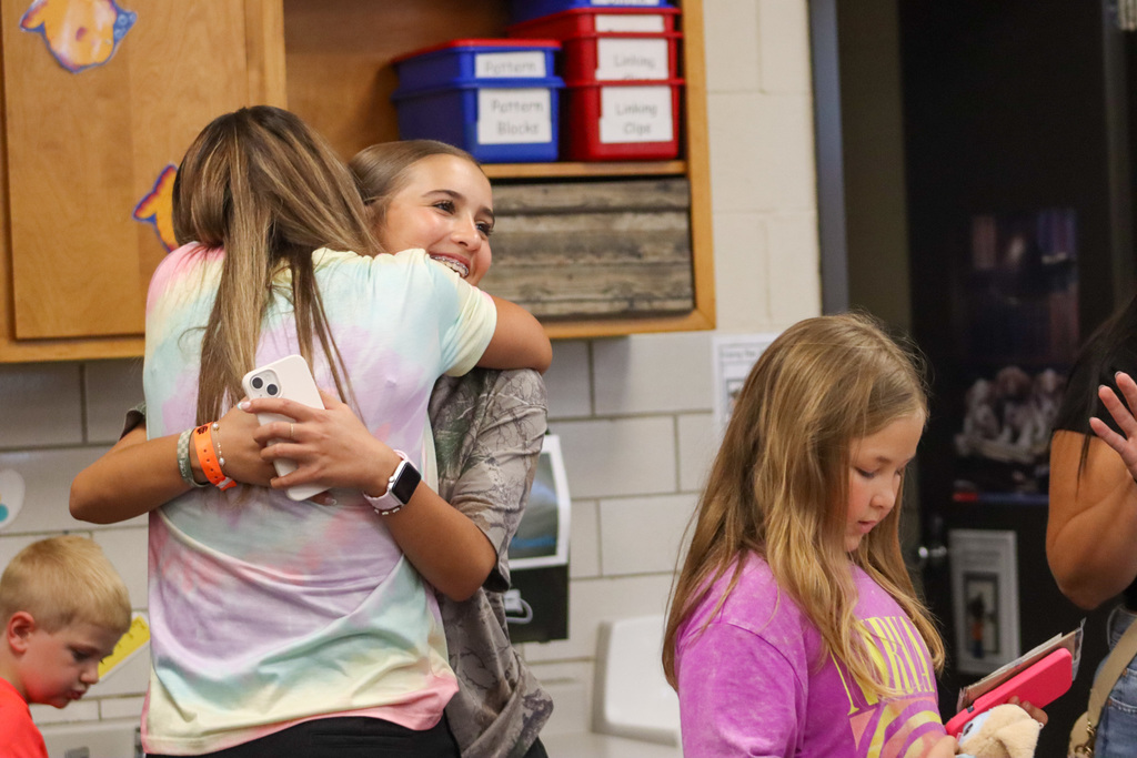 Teacher hugging student at May Overby open house