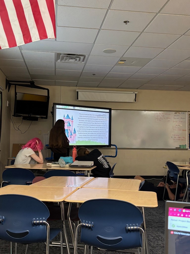 Students listen to a classmate read a story to them.