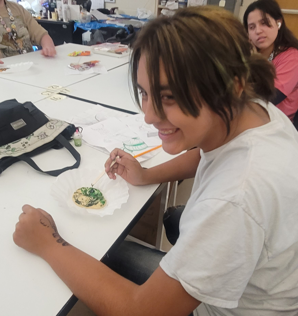 Star Three Legs is having a great time decorating a sugar cookie in Art club!