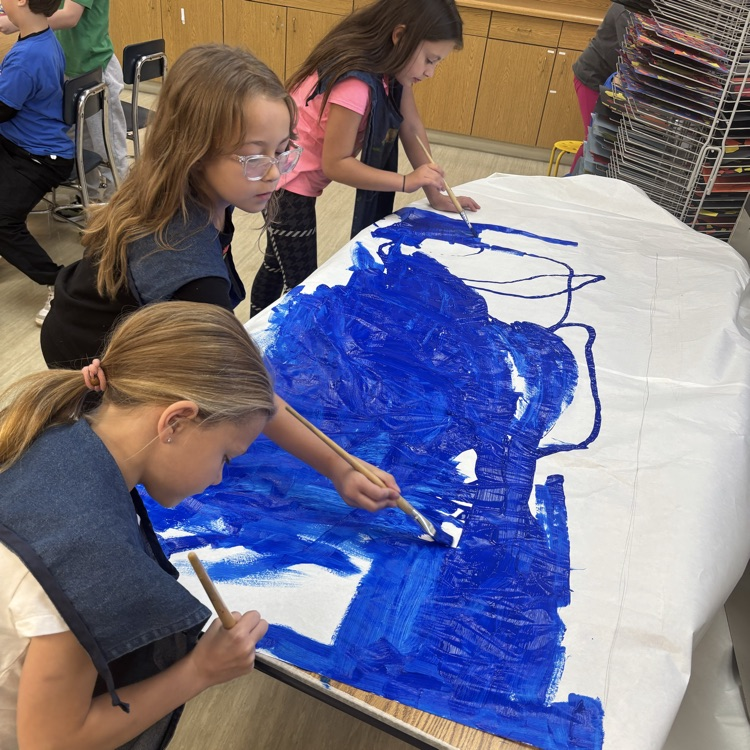 Students help prepare the background for the handprints!