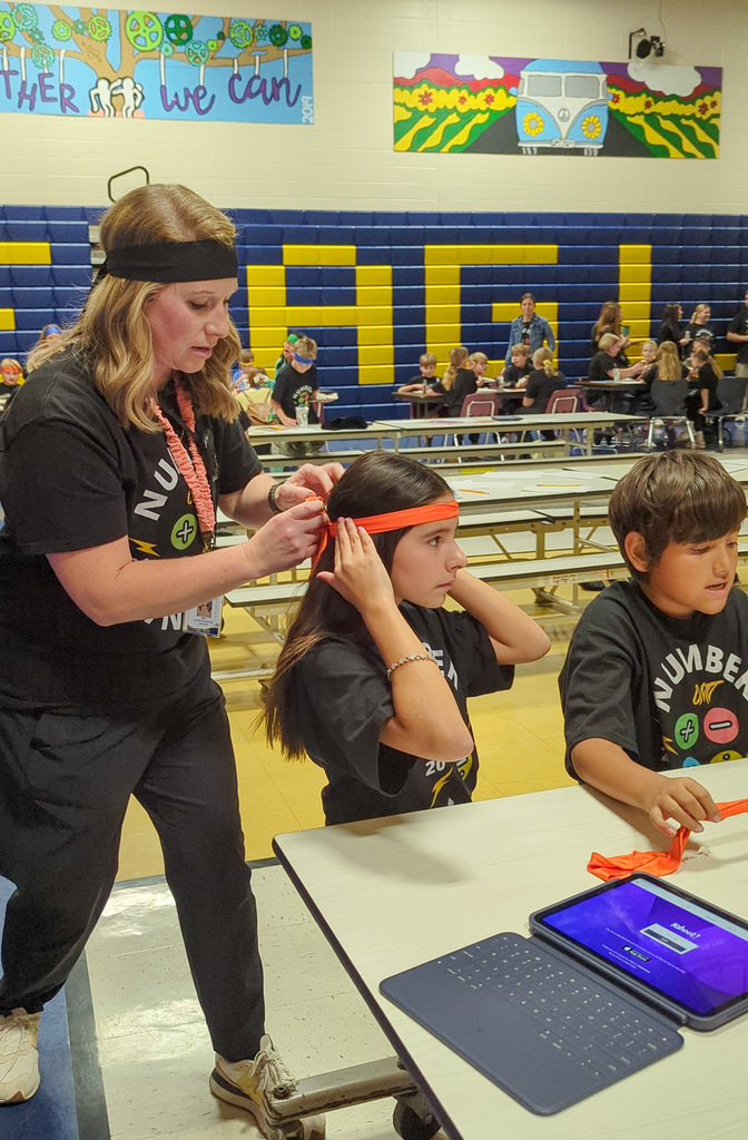 A teacher helping a Number Ninjas student with her headband