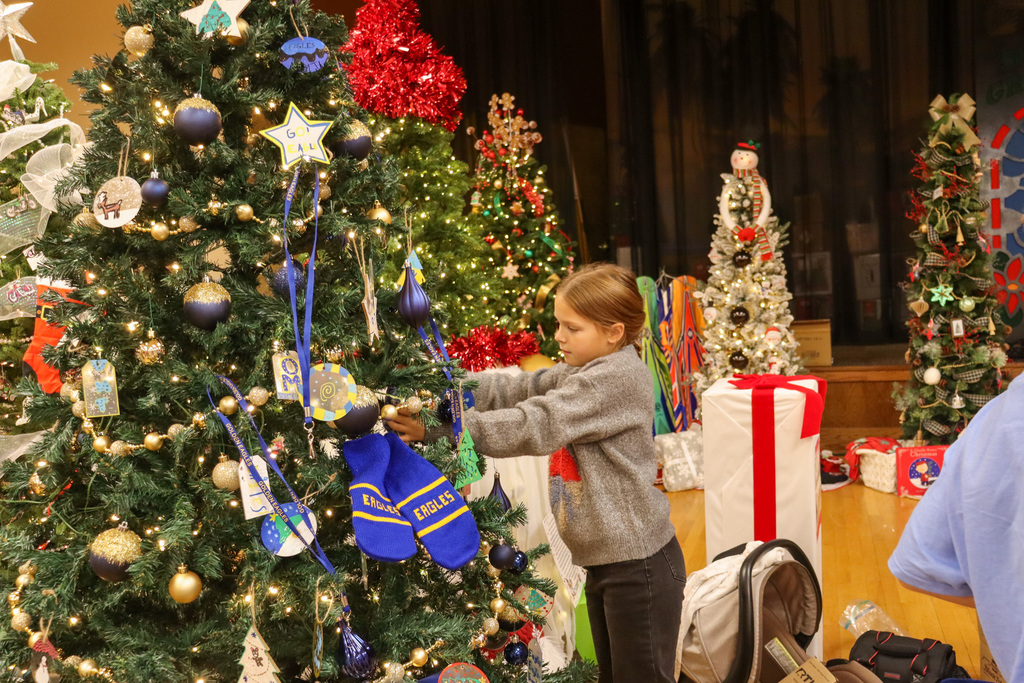 O.M. Tiffany student decorating the Golden Eagle tree at the Feztival of Trees