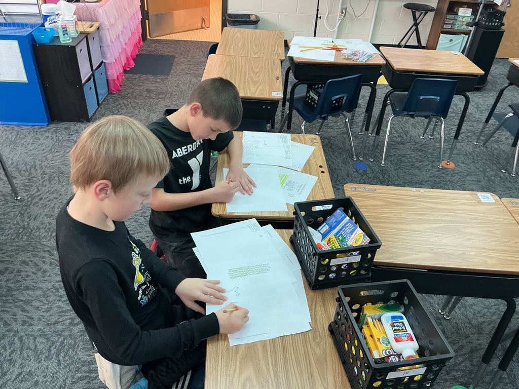 May Overby students making posters to show how plants and animals help each other