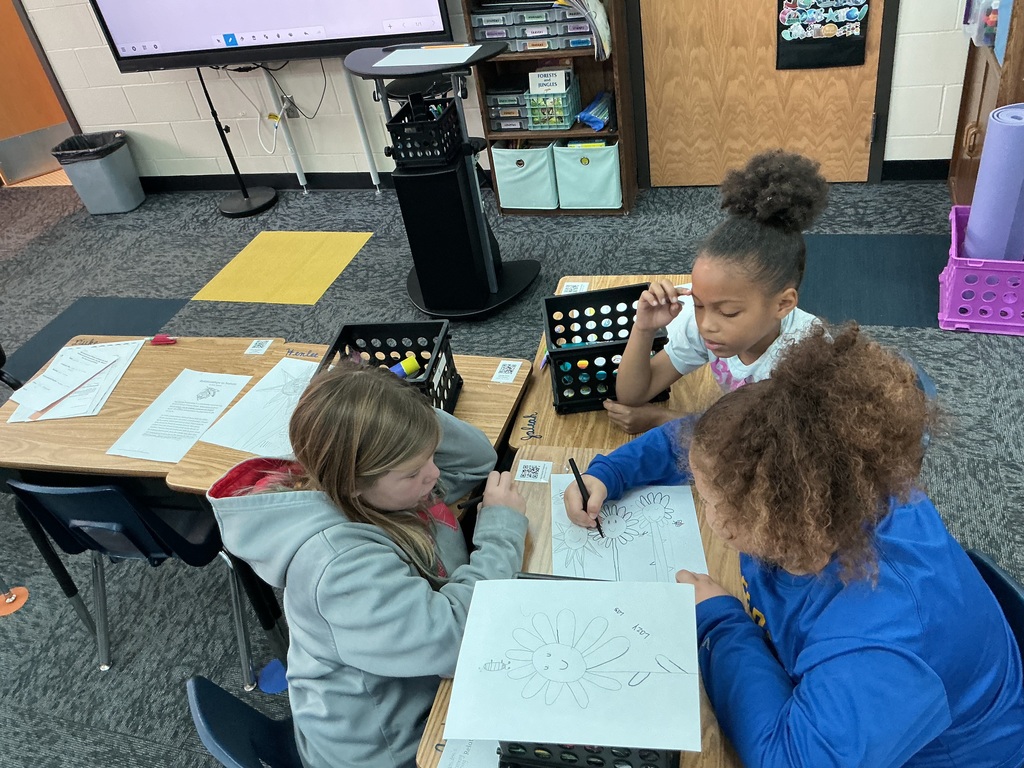 May Overby students making posters to show how plants and animals help each other