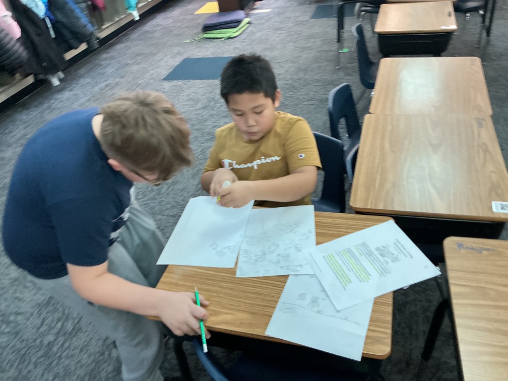 May Overby students making posters to show how plants and animals help each other