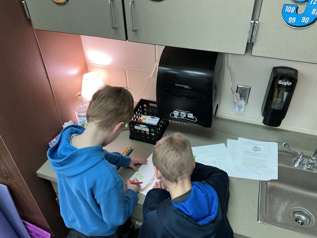 May Overby students making posters to show how plants and animals help each other