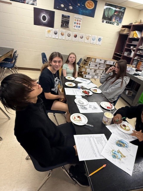 Groups collaborate as they finalize their edible cell models and prepare their written explanations.