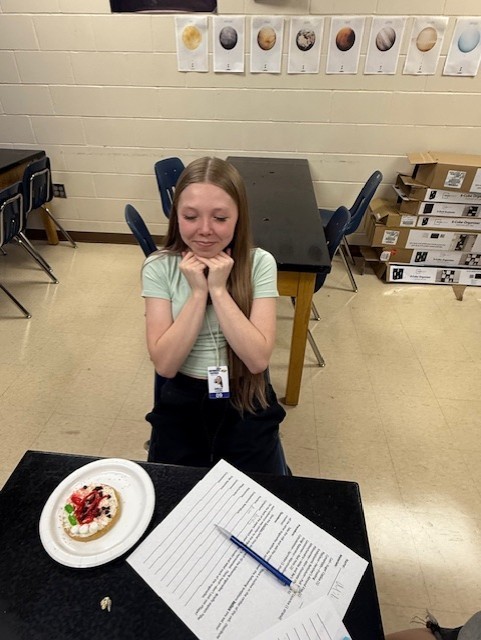 A student examines her completed cell model while reviewing the worksheet that accompanies the activity.