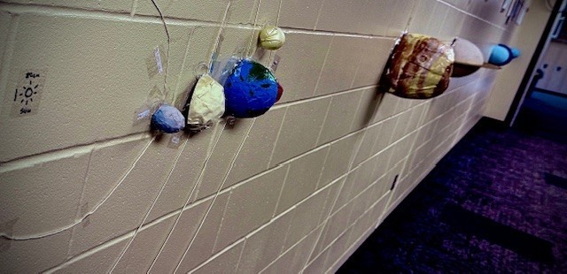 One group built a hallway-length scale model of the solar system, using the entire wall to show true planetary distances and orbital spacing.