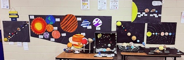 Completed solar system models on display, showing scale, orbital layout, and careful design.