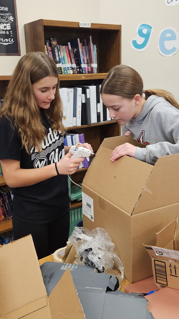 Students in Ms. Gross’ class are wrapping up their Descriptive Writing Unit with a creative culminating activity! Working in pairs, students became real estate agents for Reindeer Realty, writing vivid descriptive paragraphs to “sell” their gingerbread houses.  To bring their writing to life, students designed and built their gingerbread houses using cardboard and other materials, focusing on details that matched their descriptions.  On Friday, 6th and 7th grade students will tour the neighborhood and “purchase” the houses that best match the written descriptions. This engaging project combines creativity, collaboration, and strong writing skills—and it’s been a huge hit! 🎄🏠✏️