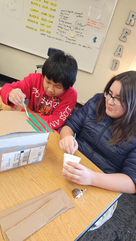 Students in Ms. Gross’ class are wrapping up their Descriptive Writing Unit with a creative culminating activity! Working in pairs, students became real estate agents for Reindeer Realty, writing vivid descriptive paragraphs to “sell” their gingerbread houses.  To bring their writing to life, students designed and built their gingerbread houses using cardboard and other materials, focusing on details that matched their descriptions.  On Friday, 6th and 7th grade students will tour the neighborhood and “purchase” the houses that best match the written descriptions. This engaging project combines creativity, collaboration, and strong writing skills—and it’s been a huge hit! 🎄🏠✏️