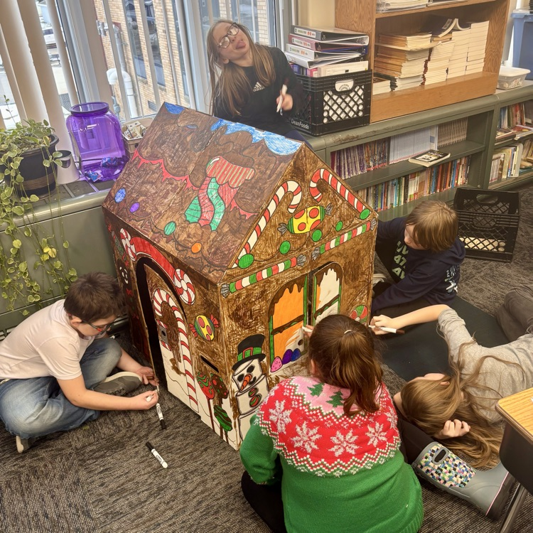 students work together to create their gingerbread houses.