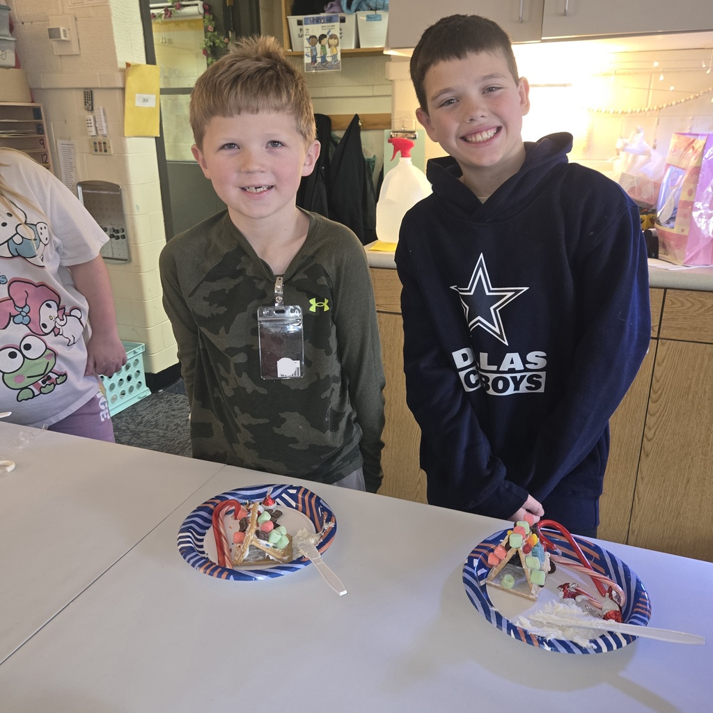 First and fifth grade students with their gingerbread houses