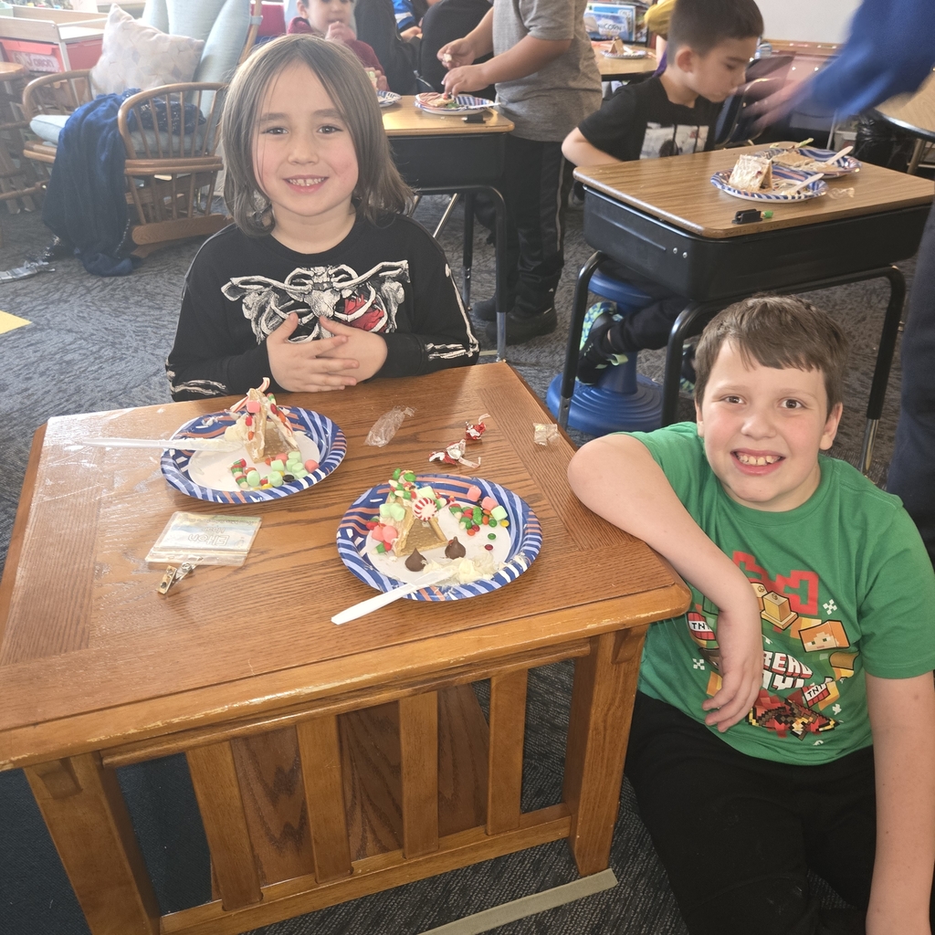First and fifth grade students with their gingerbread houses
