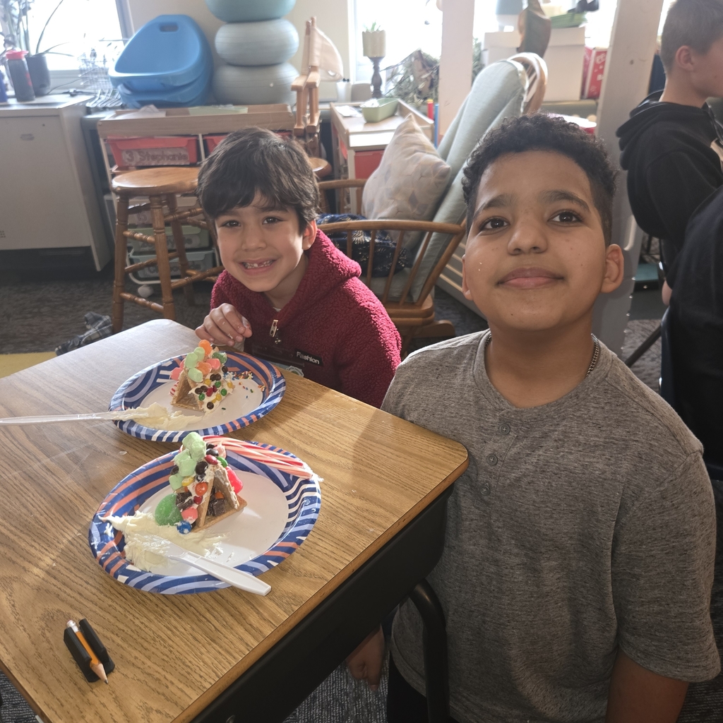 First and fifth grade students with their gingerbread houses