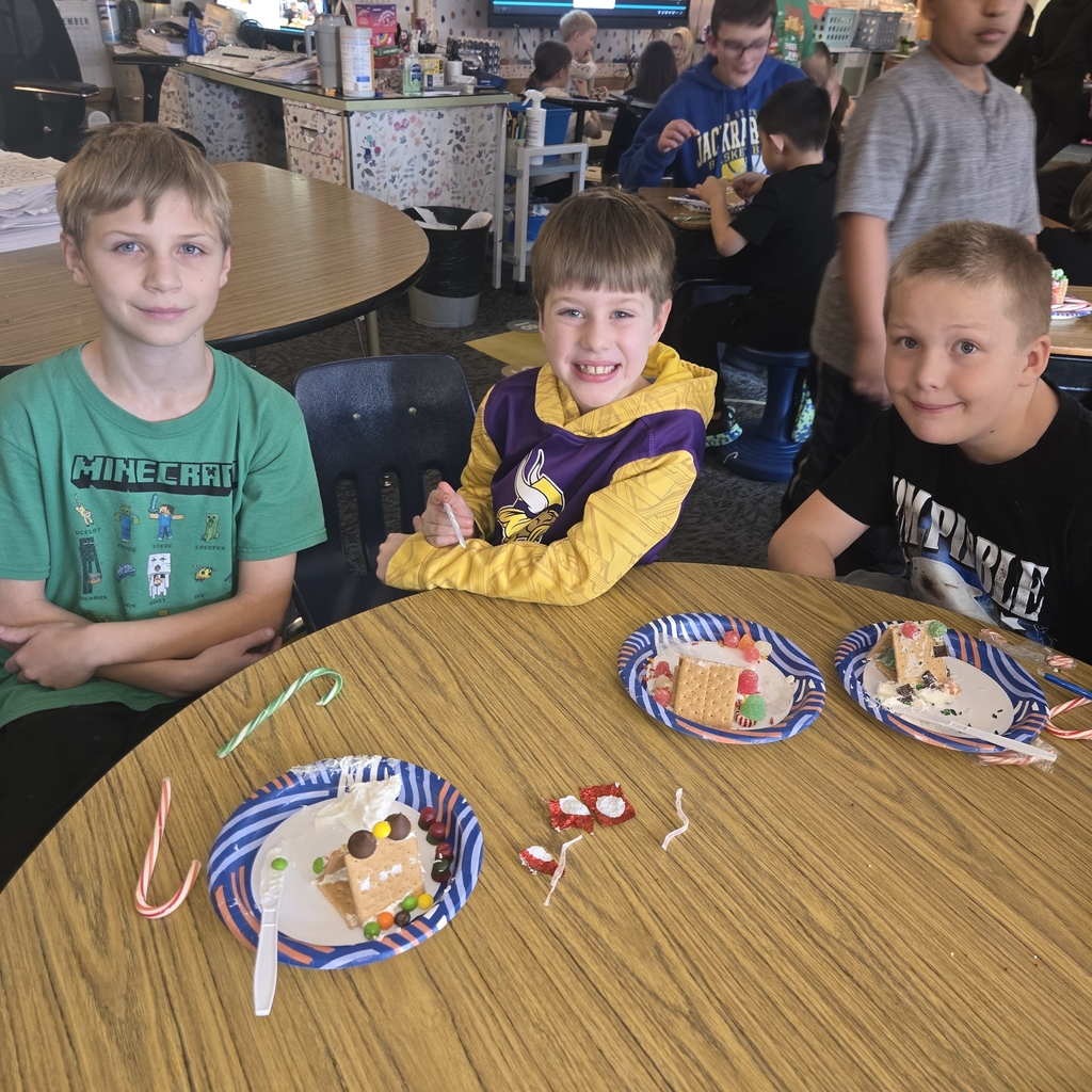 First and fifth grade students with their gingerbread houses