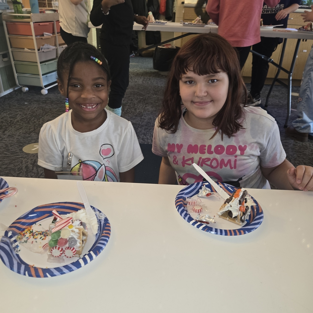 First and fifth grade students with their gingerbread houses