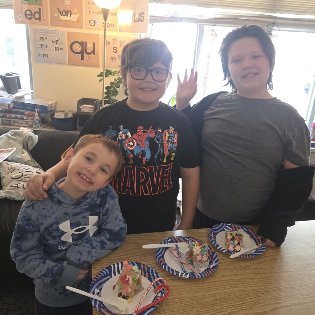 First and fifth grade students with their gingerbread houses