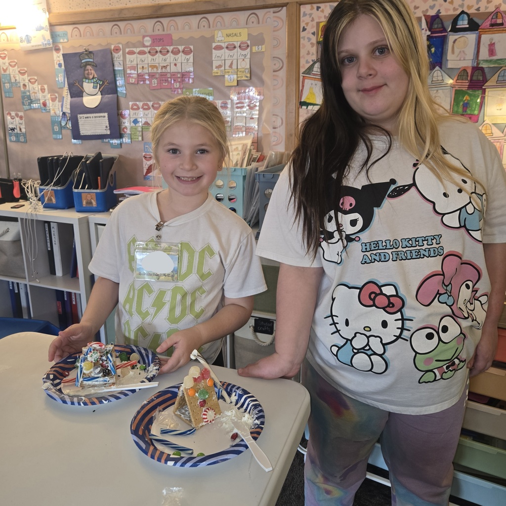 First and fifth grade students with their gingerbread houses