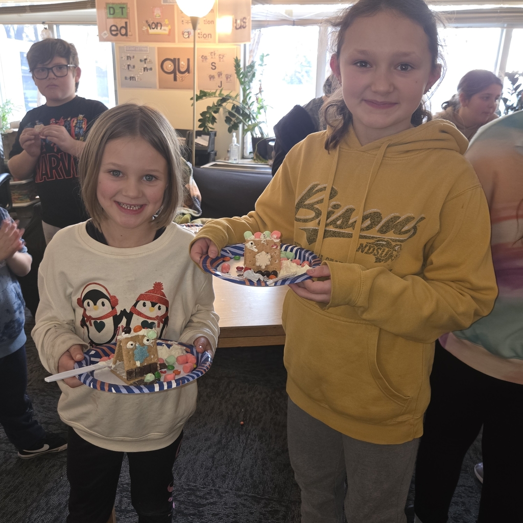 First and fifth grade students with their gingerbread houses