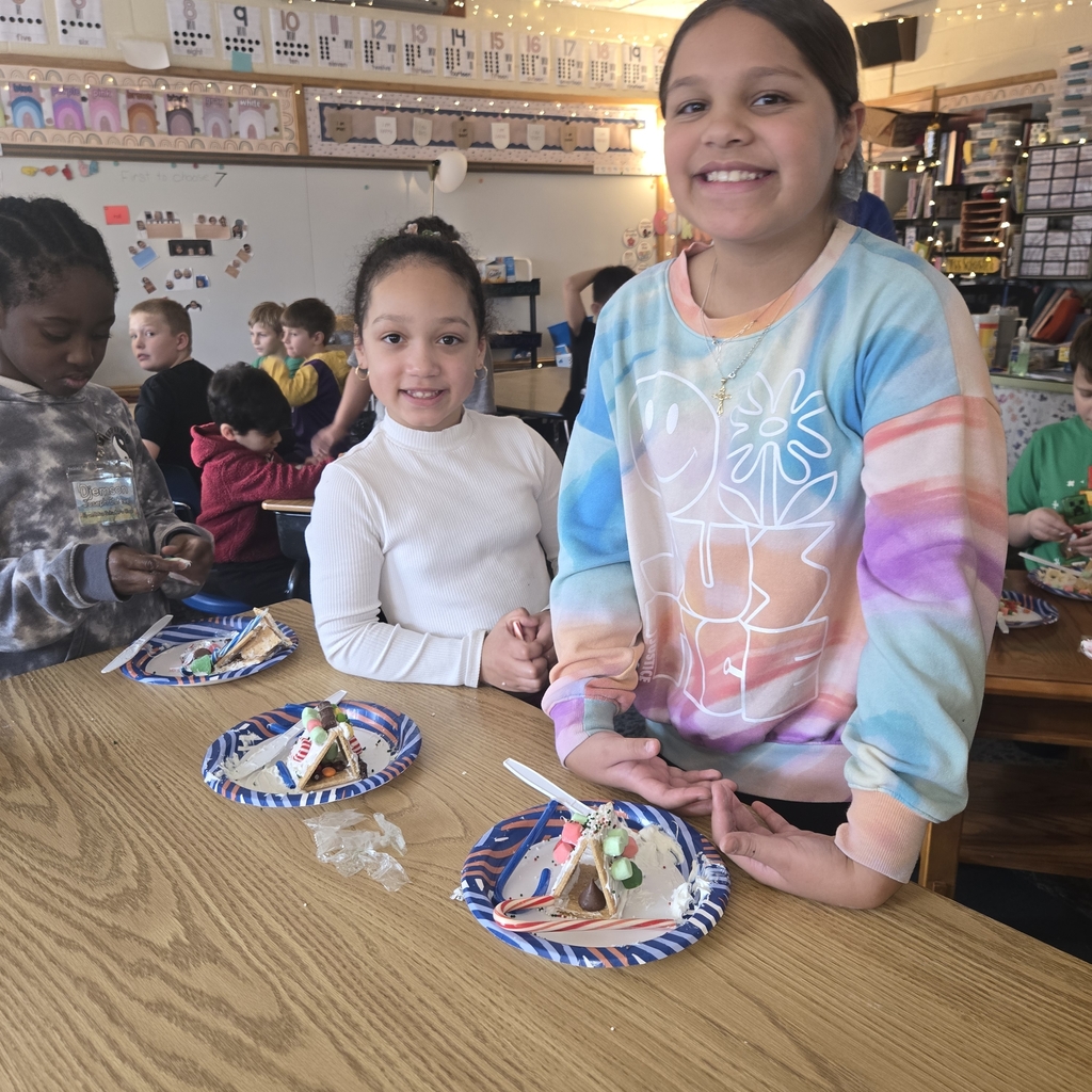 First and fifth grade students with their gingerbread houses