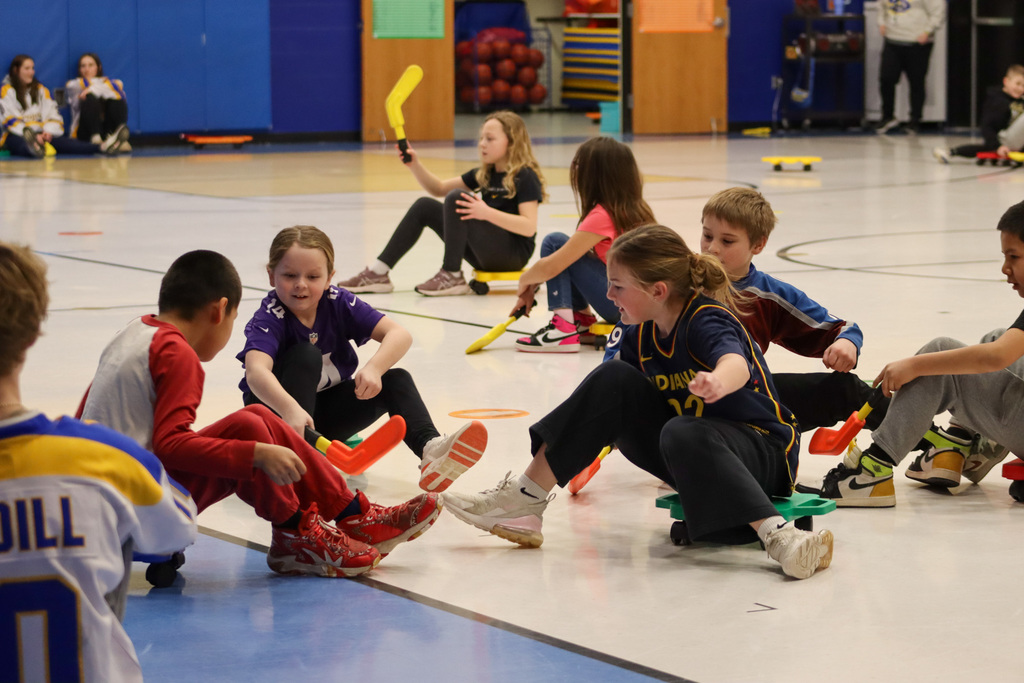 C.C. Lee students playing scooter hockey with Aberdeen Cougar Hockey players