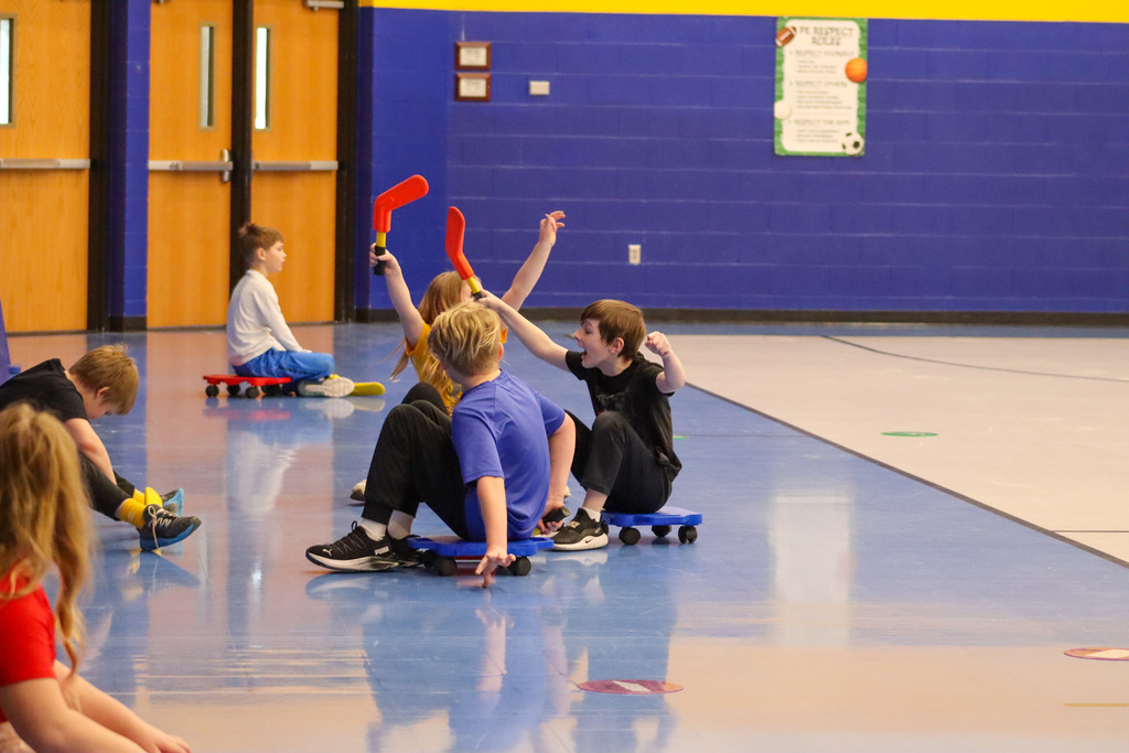 C.C. Lee students playing scooter hockey with Aberdeen Cougar Hockey players