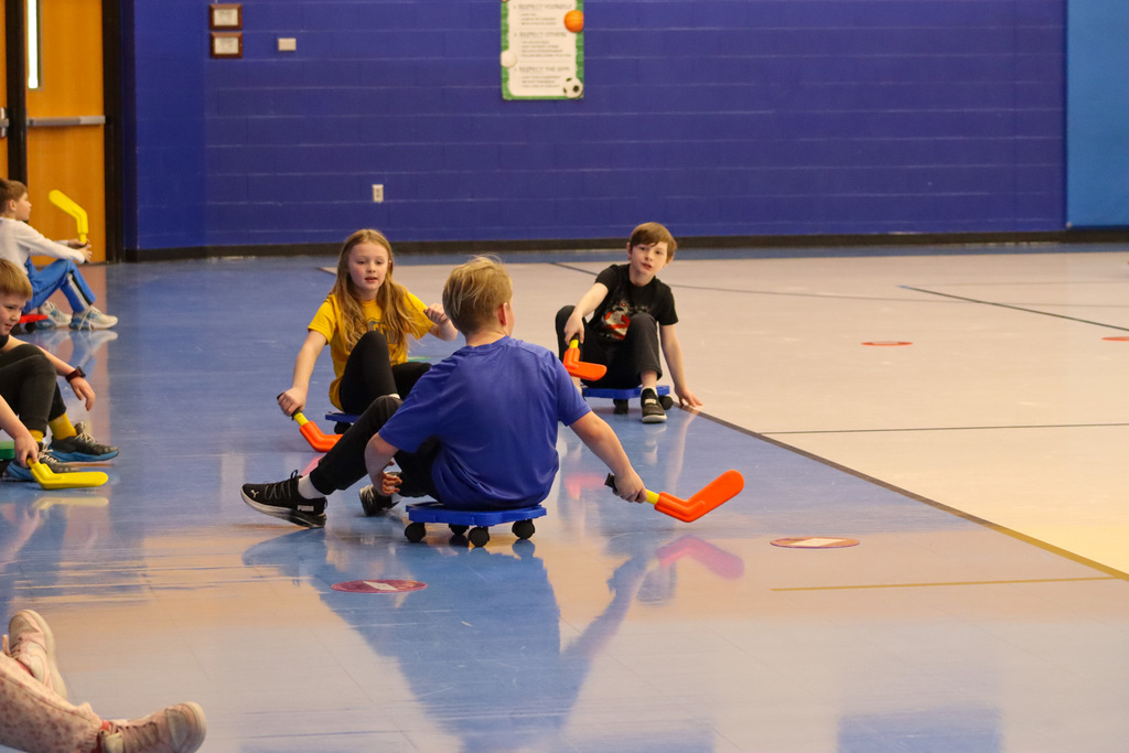 C.C. Lee students playing scooter hockey with Aberdeen Cougar Hockey players