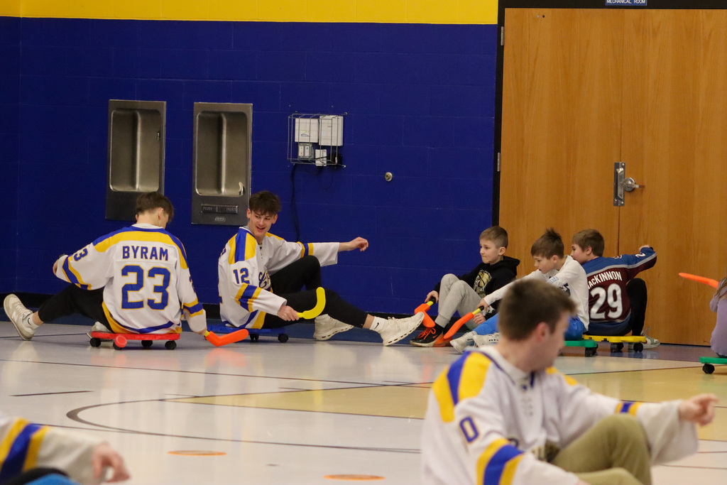 C.C. Lee students playing scooter hockey with Aberdeen Cougar Hockey players