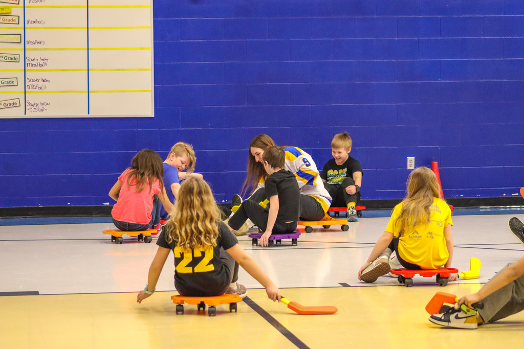 C.C. Lee students playing scooter hockey with Aberdeen Cougar Hockey players