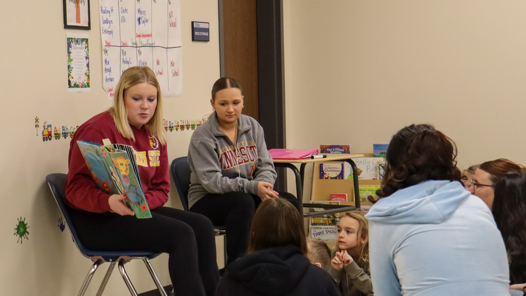 CHS student reading a story to children at Little Eagles Preschool