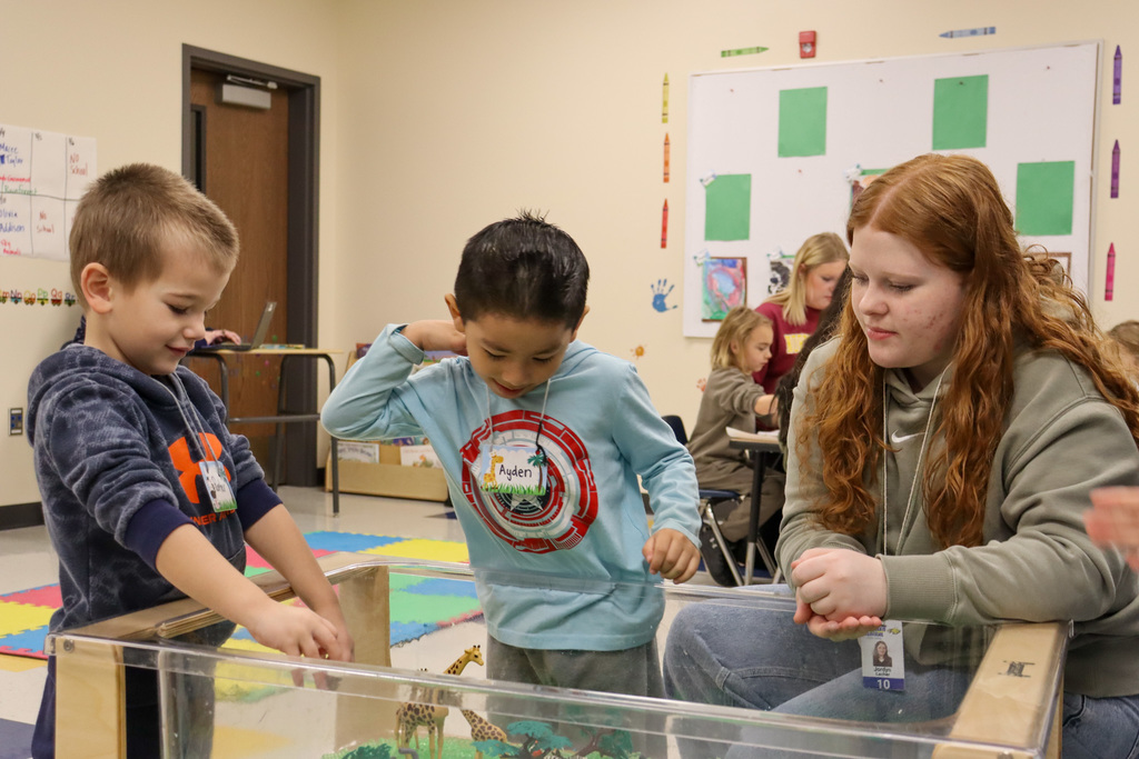 CHS student playing with two children at Little Eagles Preschool