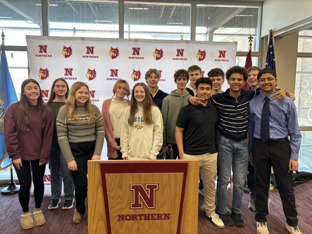 Students stand infront of the Northern State banner at the NHD Regional Contest