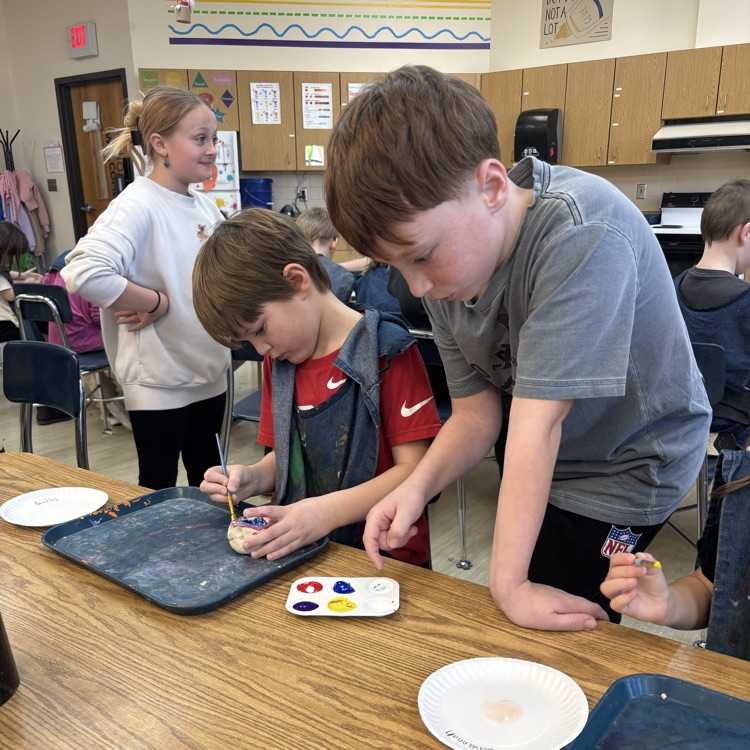 5th-graders help Kindergarten students with their pinch pots.