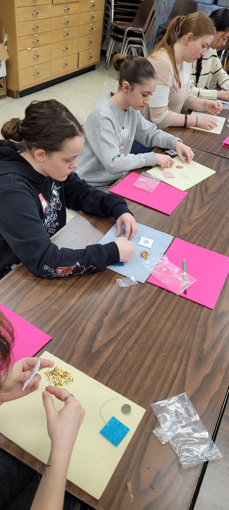 Carefully threading beads.