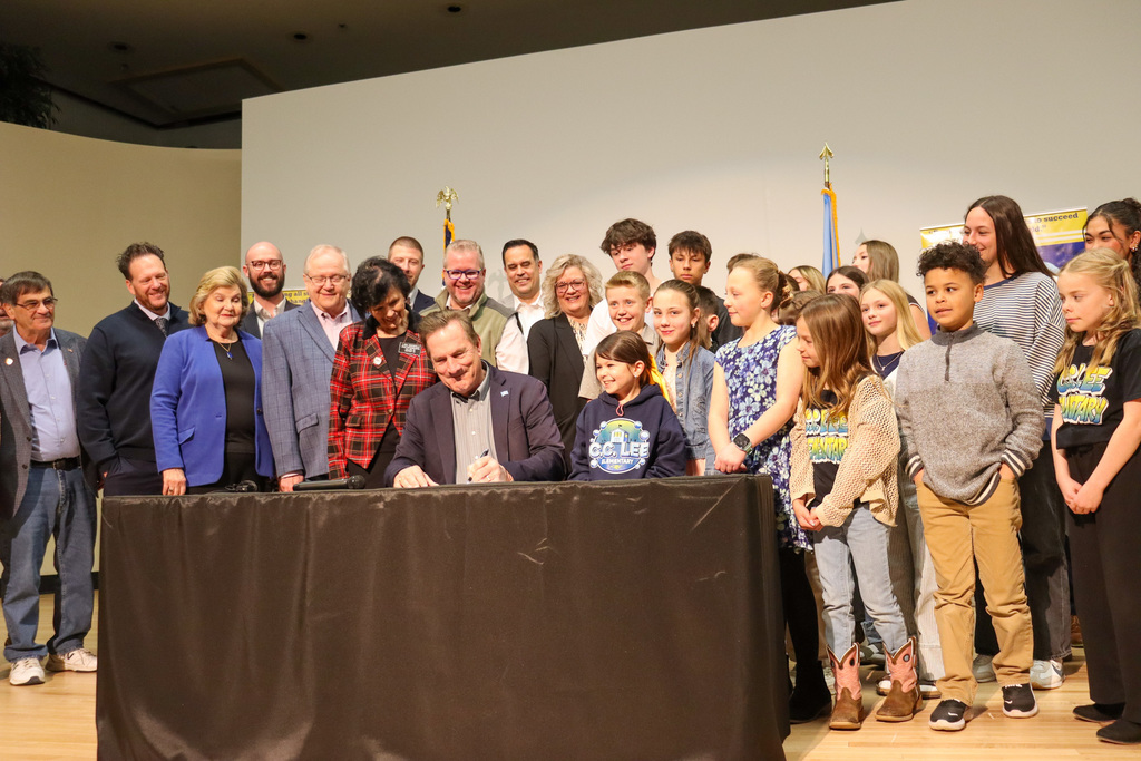 Gov. Rhoden signing a bill surrounded by local, state, and district officials as well as students from Holgate and C.C. Lee