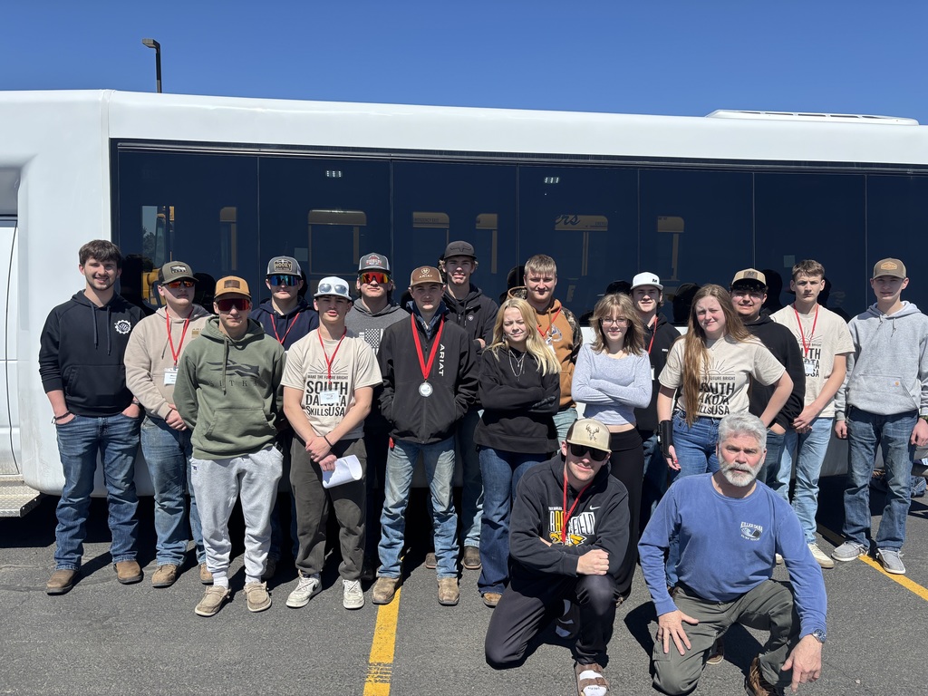 18 HS students in front of a white bus 