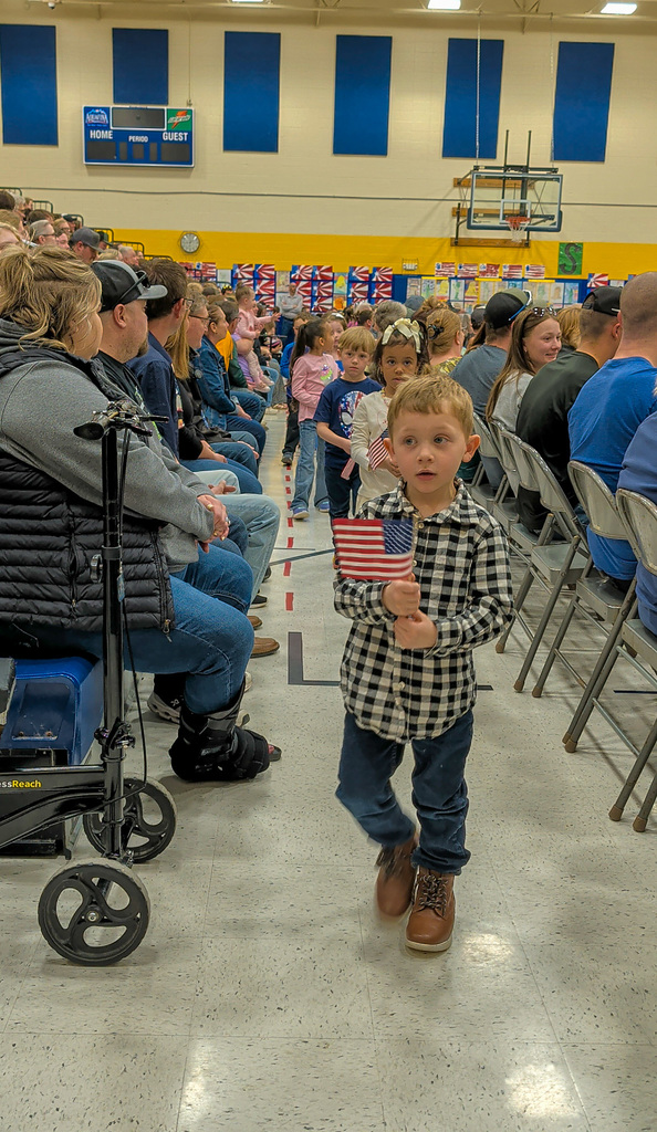 Little boy carrying American Flag at Simmons spring concert