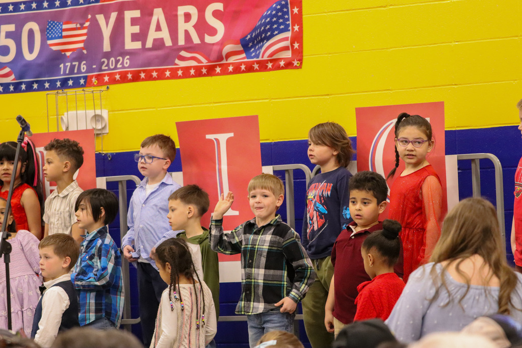 Boy waving at loved one at Simmons spring concert