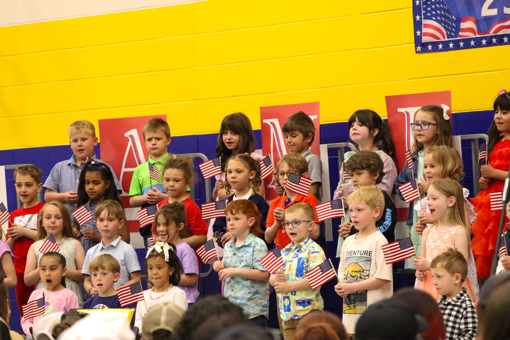 Children holding American flags at Simmons spring concert