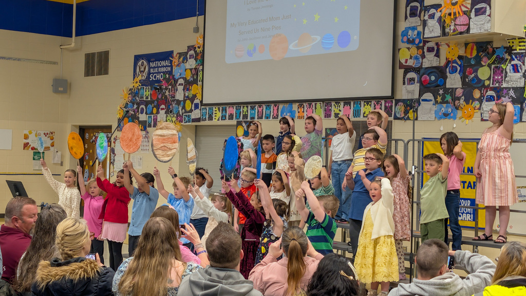 Lincoln students holding up artwork of planets at the spring program