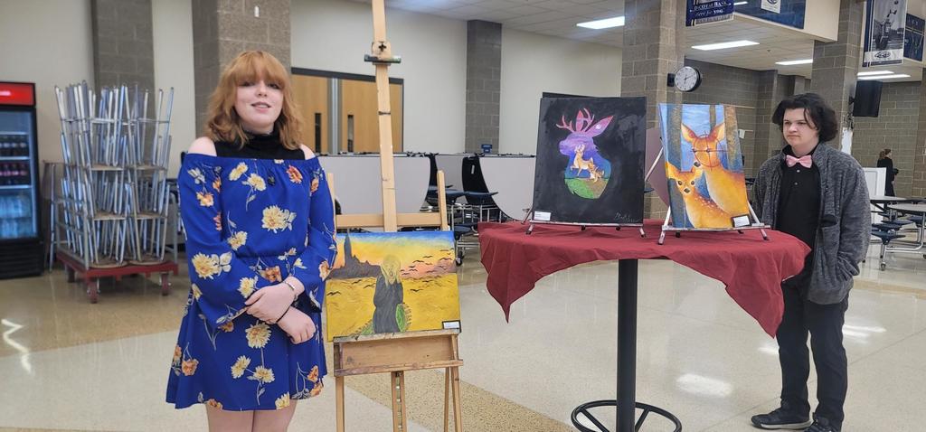 Emma Bobby poses with her amazing paintings she made in painting 2!