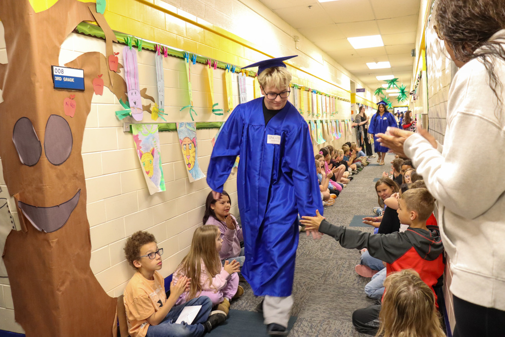 CHS graduate high fiving a Simmons Elementary student