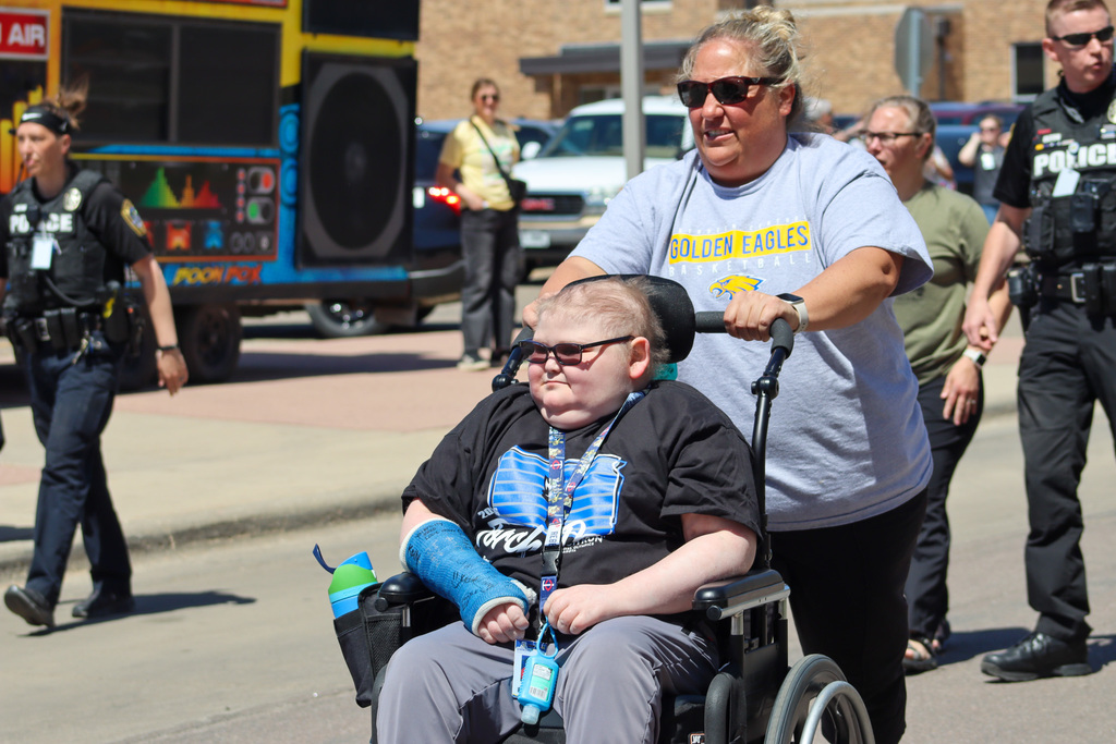 CHS coach pushing a CHS Special Olympics student in a wheel chair during the Torch Run