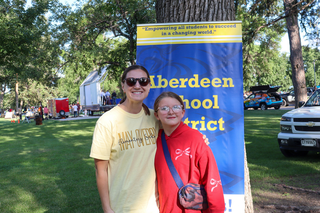 A student posing with her principal at National Night Out